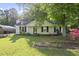 Charming single-story home with a well-manicured lawn and a cozy front porch nestled under lush greenery at 5300 Whippoorwill St, Durham, NC 27704
