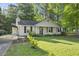 Charming home with well-maintained lawn, lush landscaping, dark shutters and a covered parking area at 5300 Whippoorwill St, Durham, NC 27704