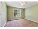 Bedroom features carpet flooring, a ceiling fan, and a window overlooking the backyard at 55 Ayden Dr, Clayton, NC 27520