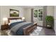 A styled bedroom with a queen-size bed, matching nightstands, and view of nature outside the window at 55 Ayden Dr, Clayton, NC 27520