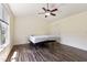 An unfurnished bedroom with hardwood floors, a ceiling fan, and a view from a large window at 55 Ayden Dr, Clayton, NC 27520