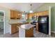 Kitchen features wood cabinets, an island, stainless appliances, and lots of natural light at 55 Ayden Dr, Clayton, NC 27520