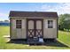 A backyard shed with double doors and white shutters on a large grassy lawn at 55 Ayden Dr, Clayton, NC 27520