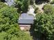 Aerial shot shows a home with gray roof amidst lush greenery and a charming wooden deck at 556 Margaret Pl, Garner, NC 27529