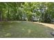 Lush backyard featuring mature trees and a well-maintained lawn, perfect for outdoor activities at 556 Margaret Pl, Garner, NC 27529