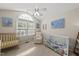Cozy bedroom features vaulted ceiling, a window, a crib, and soft chair at 556 Margaret Pl, Garner, NC 27529