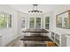 Sunlit dining room with large windows, wooden table and modern lighting fixture at 556 Margaret Pl, Garner, NC 27529