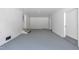 Spacious basement with white brick walls and painted concrete floors and an outside door at 5718 Woodcrest Dr, Raleigh, NC 27603