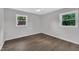 Bright bedroom with wood floors, neutral paint, and two windows offering ample natural light at 5718 Woodcrest Dr, Raleigh, NC 27603