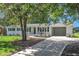 Charming, renovated home featuring a painted brick exterior, mature landscaping, and an attached carport at 5718 Woodcrest Dr, Raleigh, NC 27603
