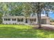 Charming, renovated home featuring a painted brick exterior, mature landscaping, and an attached carport at 5718 Woodcrest Dr, Raleigh, NC 27603