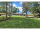 Landscaped yard leading to a beautifully painted white home with a covered carport on a sunny day at 5718 Woodcrest Dr, Raleigh, NC 27603