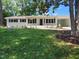 A charming brick ranch with manicured lawn, blue shutters, and covered carport entryway at 5718 Woodcrest Dr, Raleigh, NC 27603