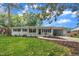 Charming white-painted home featuring dark blue shutters and front door, with attached carport at 5718 Woodcrest Dr, Raleigh, NC 27603