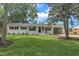 Inviting white-painted home showcasing a well-manicured lawn, complemented by dark blue shutters at 5718 Woodcrest Dr, Raleigh, NC 27603
