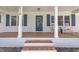 Charming front porch with brick steps, rocking chairs, and blue accents at 5718 Woodcrest Dr, Raleigh, NC 27603