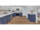 Well-lit kitchen featuring two-tone cabinetry, stainless steel appliances, quartz countertops, and vinyl plank flooring at 5718 Woodcrest Dr, Raleigh, NC 27603