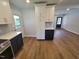 Open-concept kitchen featuring two-toned cabinets, tile backsplash, white quartz countertops, and wood-look floors at 5718 Woodcrest Dr, Raleigh, NC 27603