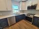 Modern kitchen features two-tone cabinets, stainless steel appliances, quartz counters, and a tiled backsplash at 5718 Woodcrest Dr, Raleigh, NC 27603