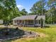 Single-story home with screened porch, lush landscaping including mature trees and garden bed; a tranquil retreat at 609 Chivalry Dr, Durham, NC 27703