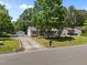 Well-maintained single-story home featuring a screened front porch, detached garage, and mature trees along the street at 609 Chivalry Dr, Durham, NC 27703