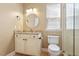 Well-lit bathroom with a granite countertop vanity, round mirror, and a glass-enclosed shower at 716 Arbor Brook Dr, Cary, NC 27519