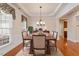 Elegant dining room featuring hardwood floors, decorative molding, and a chandelier, with table set for a formal dinner at 716 Arbor Brook Dr, Cary, NC 27519