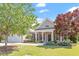Charming home featuring manicured lawn, lush landscaping, and a welcoming front porch with classic architectural details at 716 Arbor Brook Dr, Cary, NC 27519