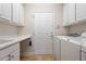 Efficient laundry room with ample counter space, white cabinets, and modern appliances at 716 Arbor Brook Dr, Cary, NC 27519