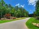 Welcome to Shinleaf Estates, a beautifully landscaped community entrance with lush greenery and trees at 7652 Falls Creek Ln, Raleigh, NC 27614