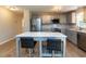 Open kitchen with stainless steel appliances, gray cabinetry, and an island with seating for two at 801 Madison Ave, Cary, NC 27513