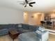 Cozy living room with a comfortable gray sectional sofa, ceiling fan, and view to the kitchen at 801 Madison Ave, Cary, NC 27513