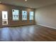 Open living room with wood floors, three windows, and a glass door for natural light at 808 Hillfarm Dr, Wake Forest, NC 27587