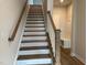 Staircase with white risers, wood treads and banister, with a bench and hooks at landing at 808 Hillfarm Dr, Wake Forest, NC 27587