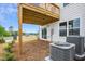 Exterior backyard with wood deck support, sliding glass doors, air conditioning units, and green shrubbery at 860 Parc Townes Dr # 70, Wendell, NC 27591