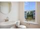 Half bathroom with sink, toilet, mirror, and window overlooking neighborhood at 860 Parc Townes Dr # 70, Wendell, NC 27591