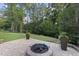 Backyard with a brick patio, fire pit, and lush green space perfect for outdoor gatherings at 1005 Collins Dr, Raleigh, NC 27609