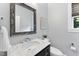Elegant powder room features a marble countertop, decorative mirror, and a contemporary faucet at 1005 Collins Dr, Raleigh, NC 27609