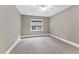 Bedroom with neutral walls, carpet floors, ceiling fan, and large window letting in natural light at 1005 Collins Dr, Raleigh, NC 27609