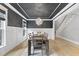 Dining room with a dark ceiling, wainscotting, modern chandelier, and wood floors at 1005 Collins Dr, Raleigh, NC 27609