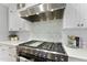 A detailed view of the stainless steel gas cooktop and modern backsplash in the kitchen at 1005 Collins Dr, Raleigh, NC 27609