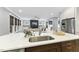 Open concept kitchen with island sink overlooking the living room with fireplace and large windows at 1005 Collins Dr, Raleigh, NC 27609
