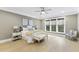 Bright bedroom featuring large windows, hardwood floors, ceiling fan and neutral tones at 1005 Collins Dr, Raleigh, NC 27609