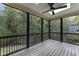 Large screened-in porch with a ceiling fan and views of the surrounding woods at 1005 Collins Dr, Raleigh, NC 27609