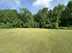 Large, open backyard with a lush lawn and mature trees at 1021 Forest Glen Dr, Raleigh, NC 27603