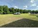 Expansive backyard featuring a shed, covered parking, trampoline and mature trees at 1021 Forest Glen Dr, Raleigh, NC 27603