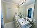 Bathroom featuring double sinks, large mirror, and modern fixtures at 1021 Forest Glen Dr, Raleigh, NC 27603