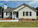 Charming single-story home with a metal roof, tidy landscaping, and an inviting front porch entrance at 1021 Forest Glen Dr, Raleigh, NC 27603