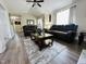 Open-concept living room with wood floors, leather sofas, and a decorative rug at 1021 Forest Glen Dr, Raleigh, NC 27603