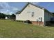 Large side yard with lush lawn featuring the home's siding and central A/C unit at 1021 Forest Glen Dr, Raleigh, NC 27603